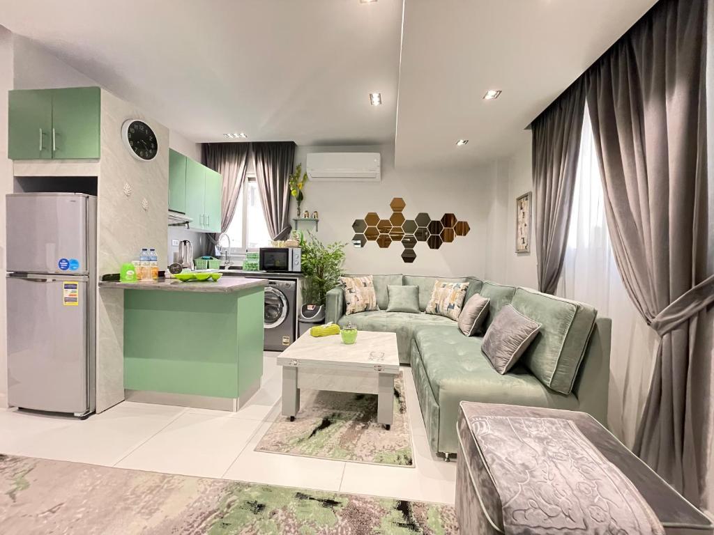 Luxury Studio House 589-3 في السادس من أكتوبر: غرفة معيشة مع أريكة خضراء ومطبخ