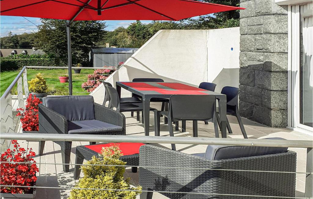 une terrasse avec une table, des chaises et un parasol dans l'établissement 3 Bedroom Awesome Home In Saint-carreuc, à Saint-Carreuc