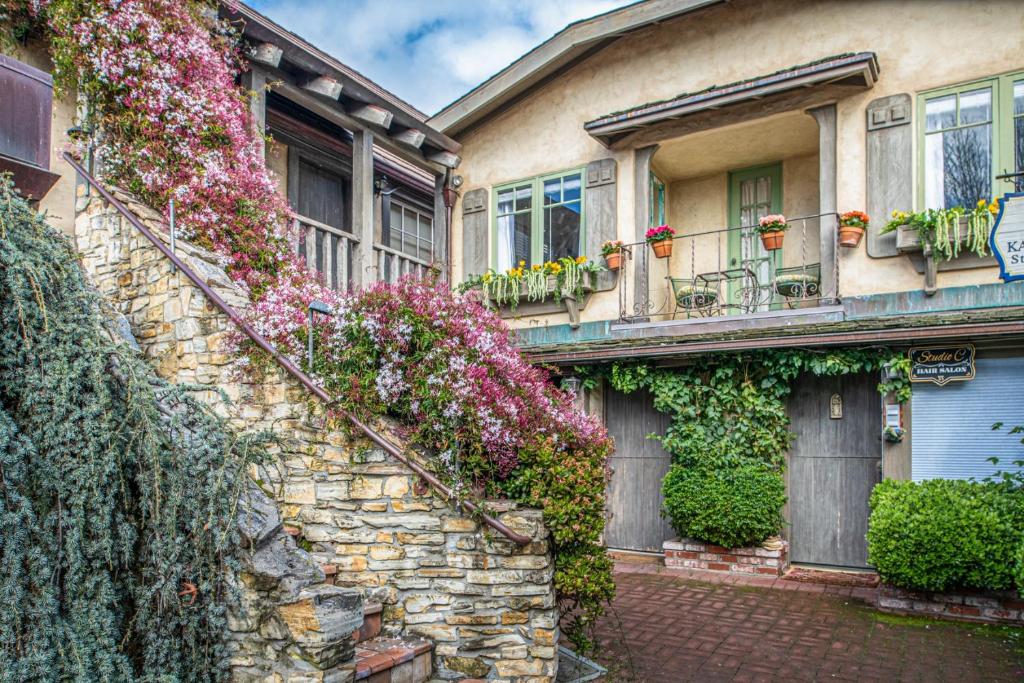 a stone house with flowers on the side of it at 3795 The Artist's Way apts in Carmel