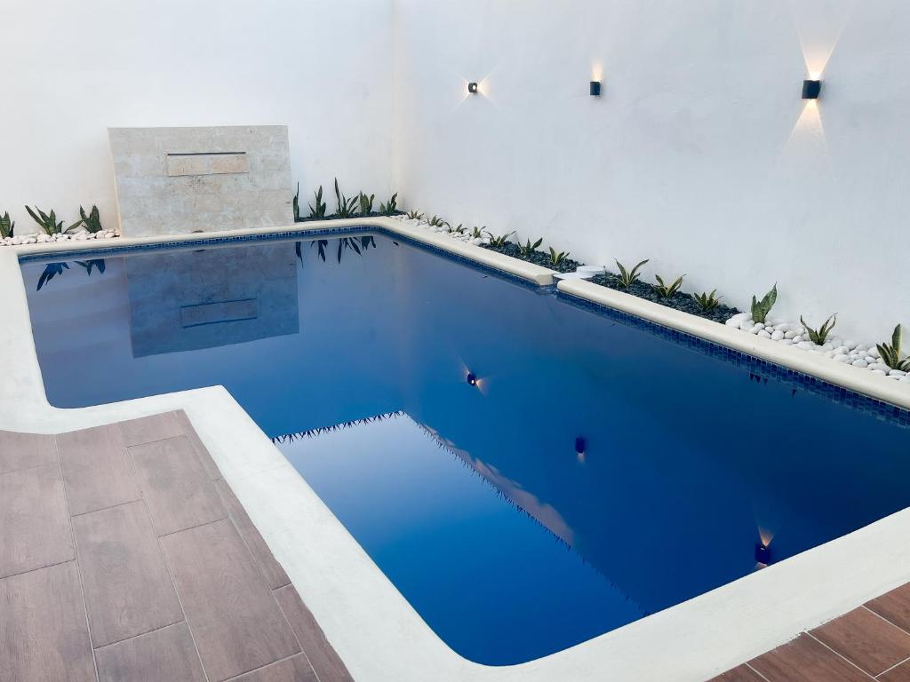 einen Pool mit blauem Wasser in einer weißen Wand in der Unterkunft Villa Ana Luisa - Pool, AC, 3min to Beach, Modern 3BD/3.5BA in La Romana