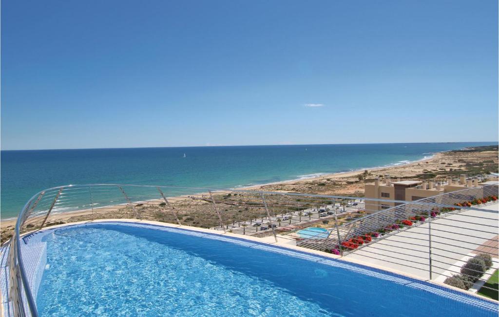 een zwembad met uitzicht op het strand bij Beautiful Apartment In Elche With Kitchenette in Arenales del Sol