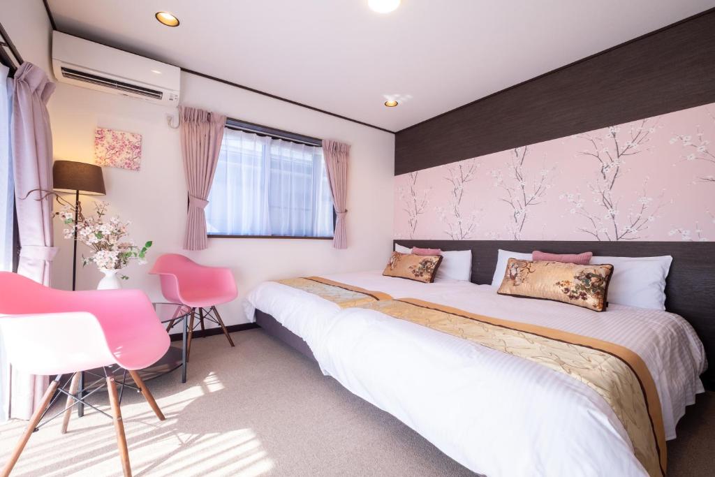 sypialnia z 2 łóżkami i różowymi krzesłami w obiekcie スカイハウス富士河口湖 w mieście Fujikawaguchiko