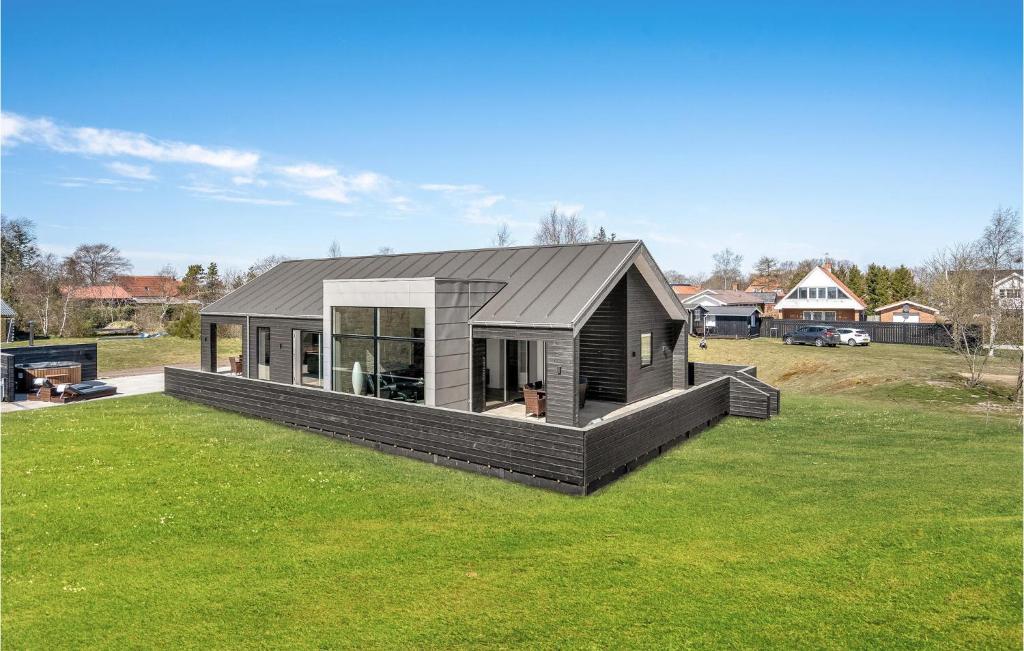 una casa con techo negro en un campo de césped en Cozy Home In Hadsund With Wifi, en Hadsund