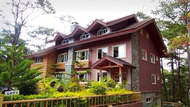 a large wooden house with a fence in front of it at CAMPJOHNHAY Forest Estate in Baguio