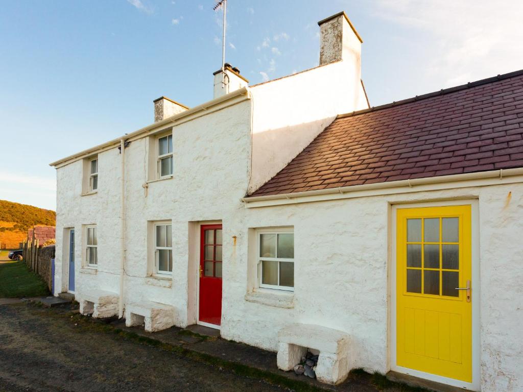 a white house with a yellow and red door at Yellow - Uk43117 in Clynnog-fawr