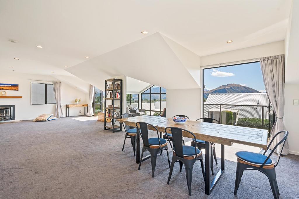 a dining room with a table and chairs and a large window at IRONSIDE LAKEVIEW TOWNHOUSE in Wanaka