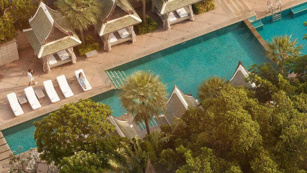 曼谷的住宿－The Peninsula Bangkok，享有棕榈树游泳池的顶部景致