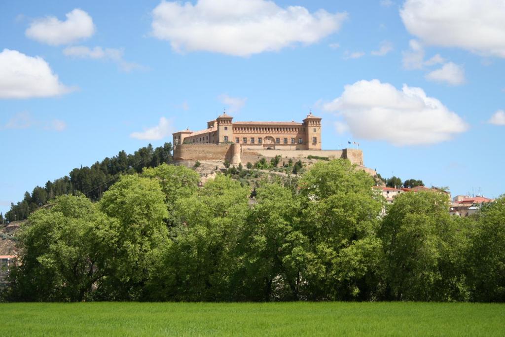 a castle on top of a hill with trees at Parador de Alcañiz in Alcañiz