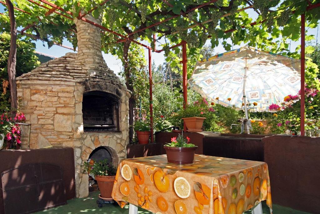 a patio with a table and a stone oven at Apartments Duda in Pula