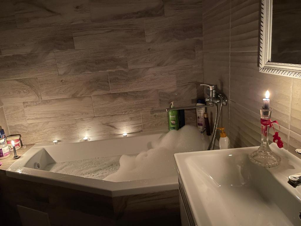 a bathroom with a tub with lights in it at Svetlana Apartment in Chişinău