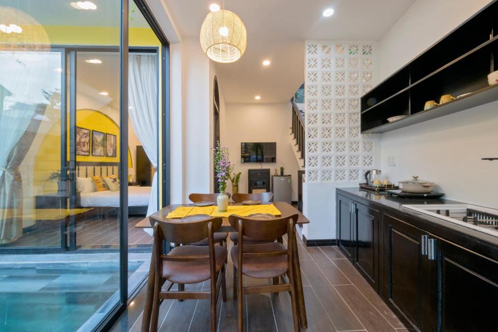 a kitchen and dining room with a table and chairs at Hoi An Rosie Villa - 2 Bedrooms with Private Pool and Local Hoi An Decor in Hoi An