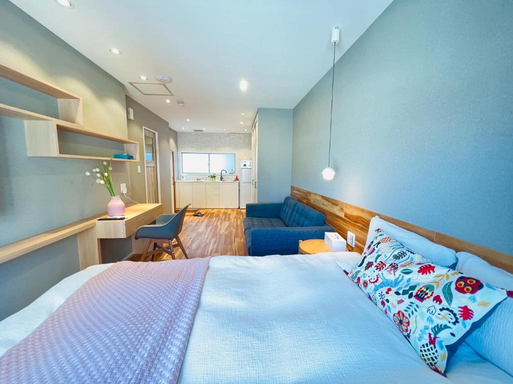 sypialnia z łóżkiem i niebieską ścianą w obiekcie ZDT w Tokio