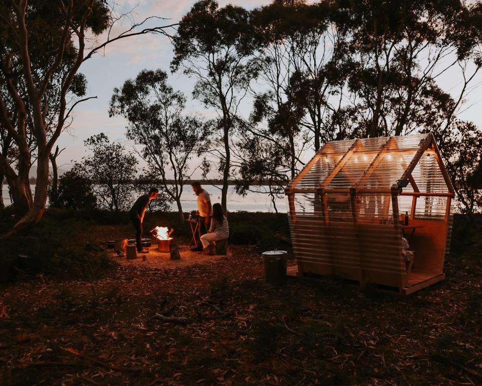 un grupo de personas sentadas alrededor de una casa de pájaros en Numie - Freycinet Peninsula - Glamping, en Coles Bay