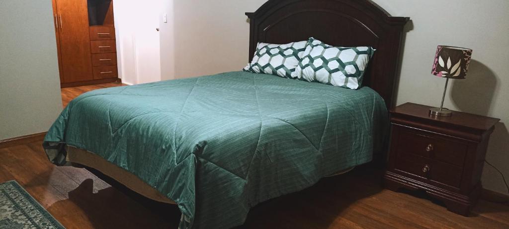 - une chambre avec un lit et une couette verte dans l'établissement Departamento de lujo Mexicali #3, à Mexicali