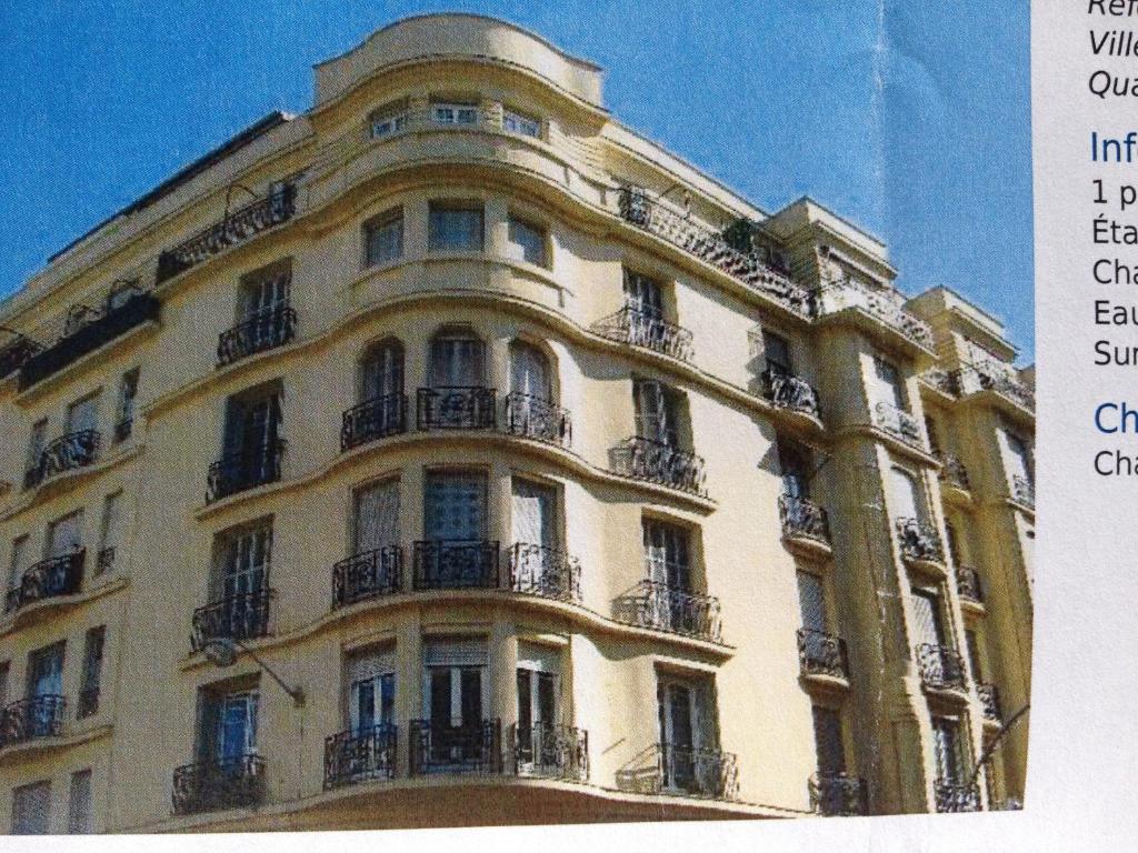 a large white building with balconies on top of it at Studio Carré d'Or, à 50 m de la plage et du Négresco in Nice