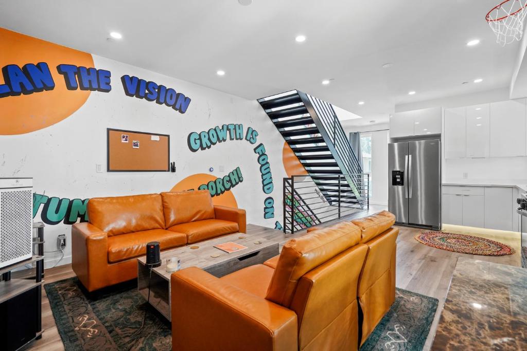 a living room with two couches and a staircase at Eye-Opening And Ultra-Secure Luxury Hollywood Condo in Los Angeles