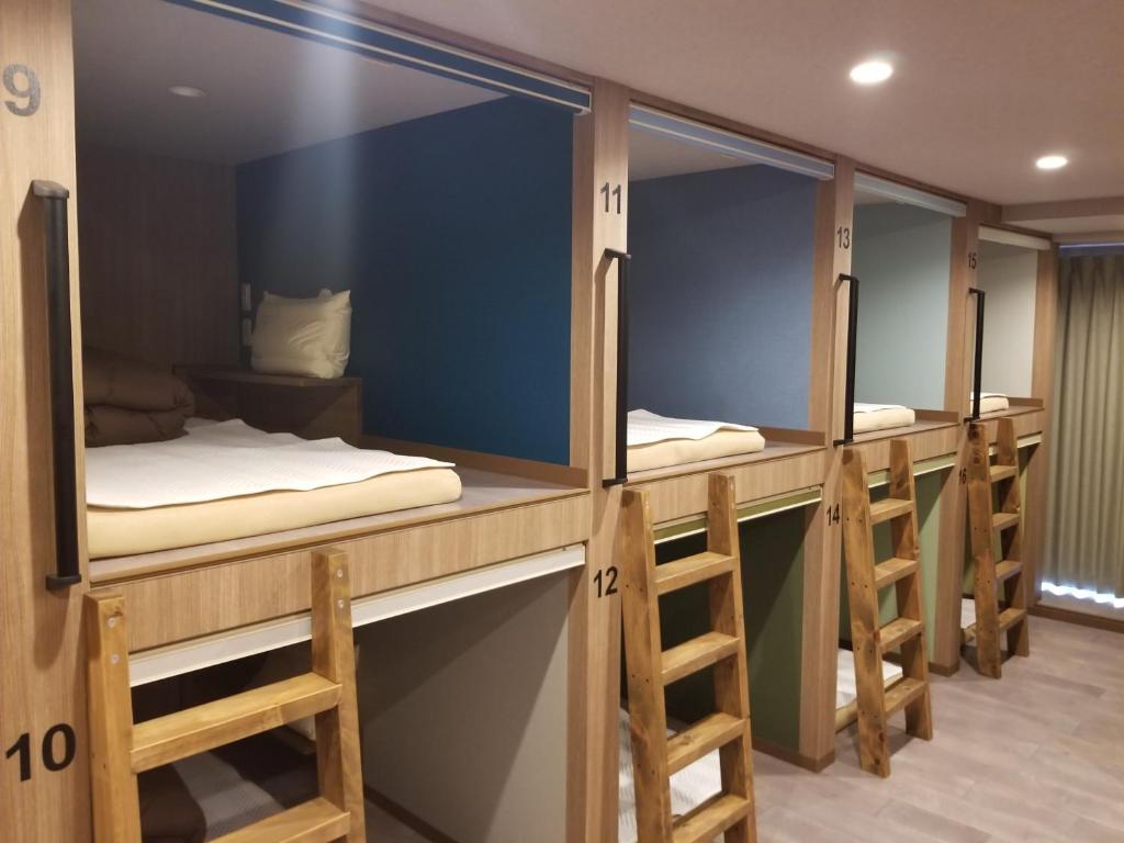 a row of bunk beds in a dorm room at Hotel Eco Dogo in Matsuyama