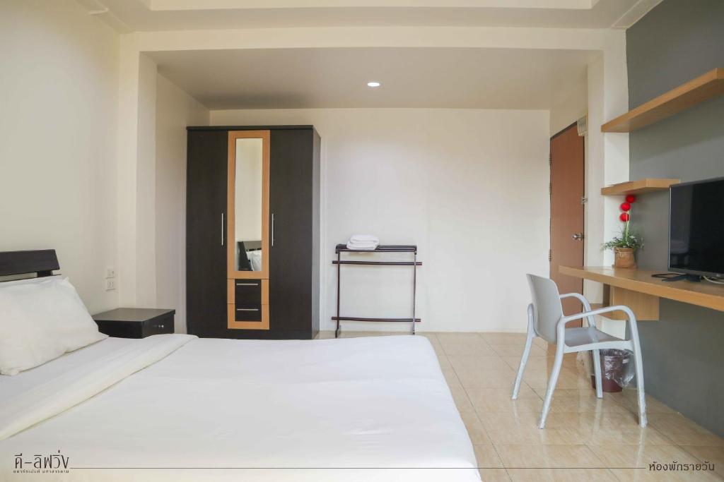 1 dormitorio con 1 cama blanca grande y escritorio en ดีลิฟวิ่ง เพลส มหาสารคาม, en Maha Sarakham