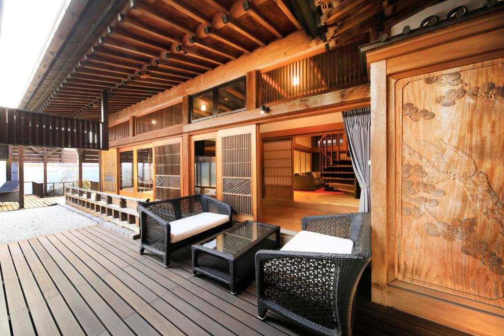 a deck with chairs and tables on a building at Fuji Onsenji Yumedono in Fujikawaguchiko