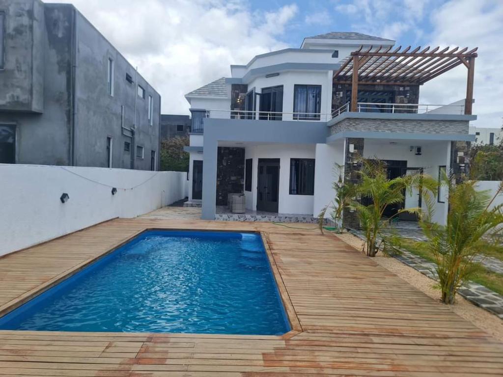 a villa with a swimming pool in front of a house at Silverwood in Pereybere