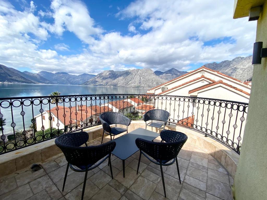 a balcony with a table and chairs overlooking a lake at 2montenegro MIMOZA Apartments in Dobrota