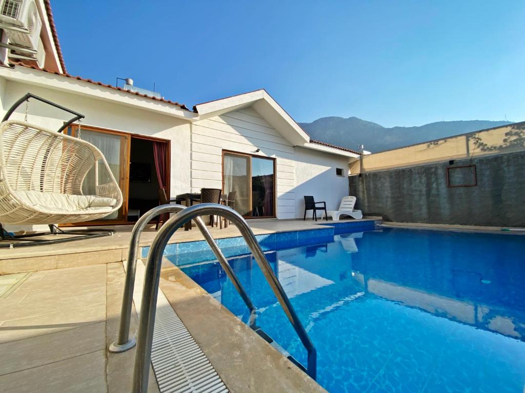 a swimming pool in front of a house at Likya Akik 2+1 Villa, Özel Havuzlu in Fethiye