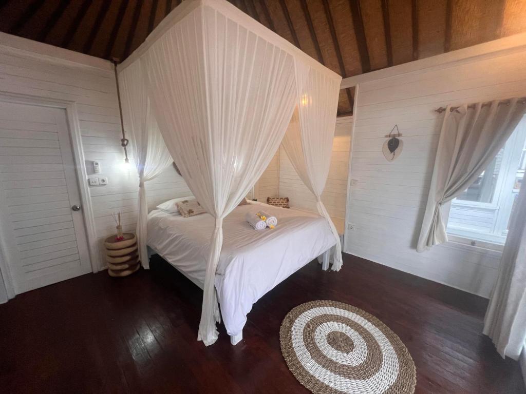 - une chambre avec un lit doté de draps et de rideaux blancs dans l'établissement The KUBU 221, à Nusa Lembongan