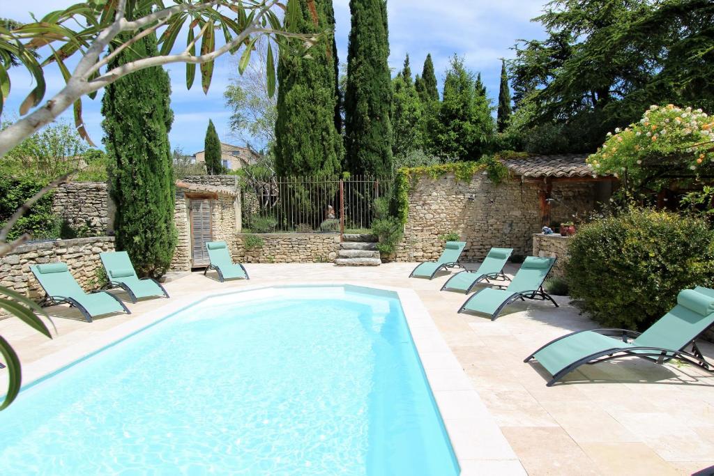 a pool with chaise lounge chairs and a patio at Gites Provence et Nature - séjours de rêve entre Luberon et Monts de Vaucluse in Cabrières-dʼAvignon