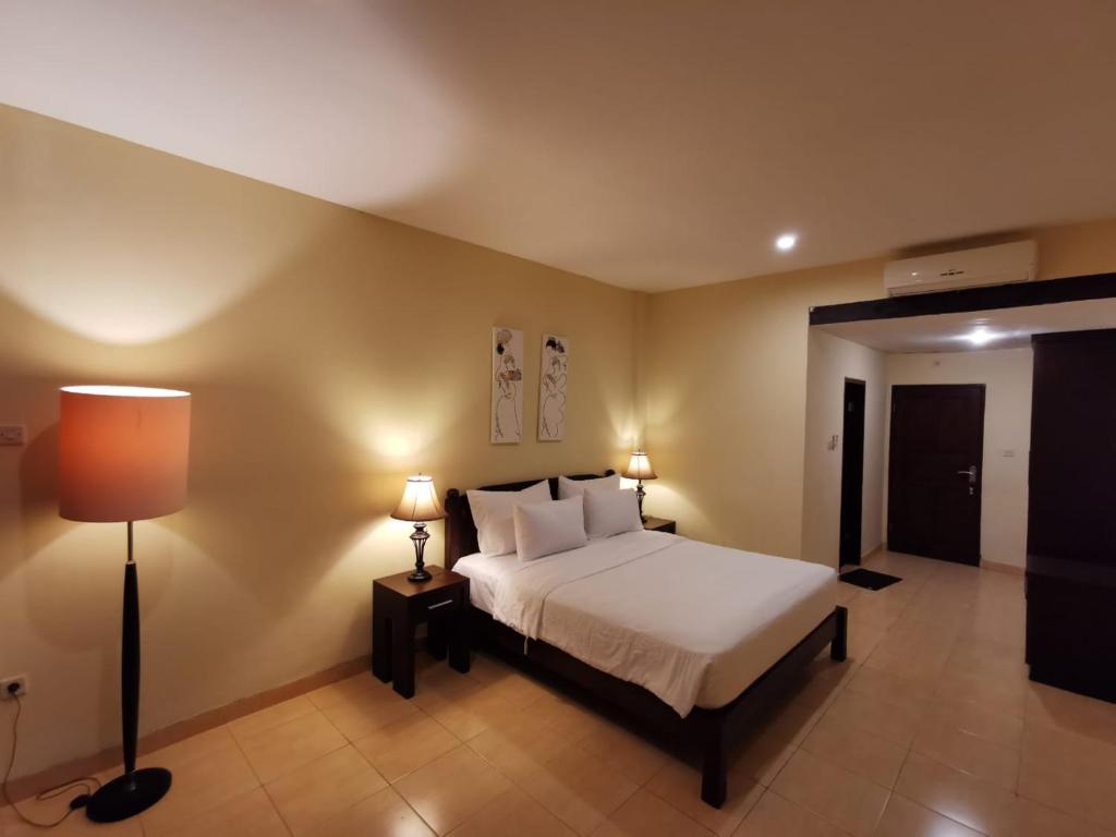 a bedroom with a white bed and two lamps at Dalia Budget Hotel in Senggigi