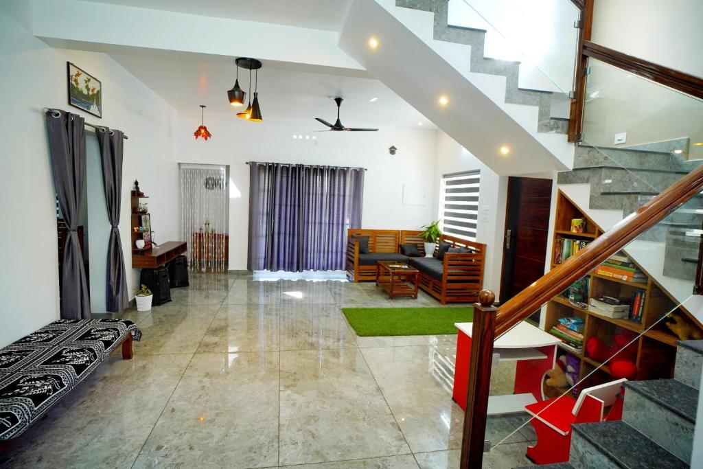 - un salon avec un escalier et un canapé dans l'établissement Vaishnavam Home stay, à Thekkady