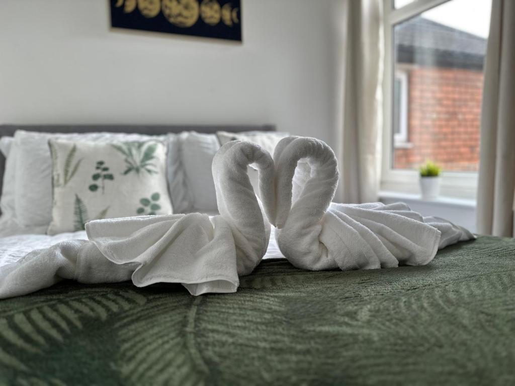 a pair of towel animals sitting on top of a bed at No 1 Seafield - Sleeps 5 - Lincoln City in Lincolnshire
