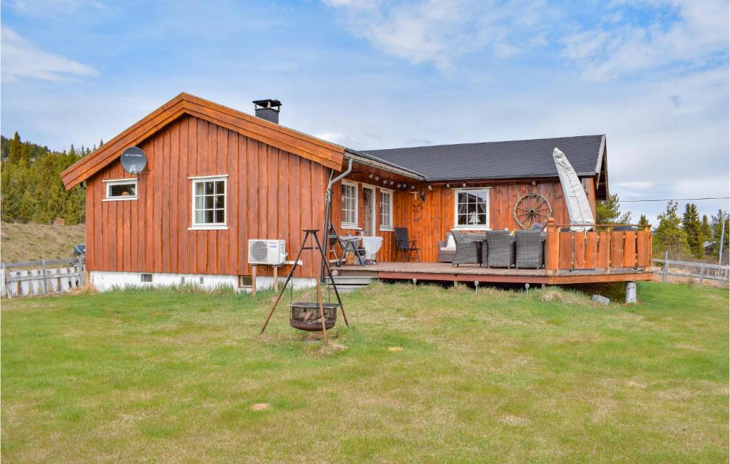 a small wooden house with a porch and a yard at Awesome Home In Leira I Valdres With Kitchen in Leira