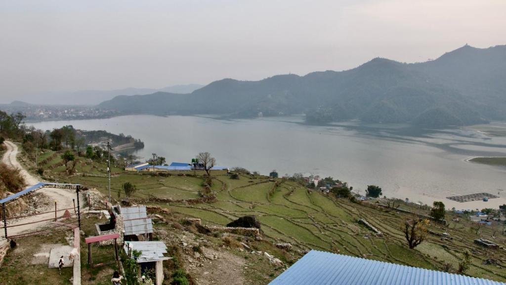 una vista de un gran cuerpo de agua con montañas en Fewa View Cottage and Yoga Retreat Homestay en Pokhara