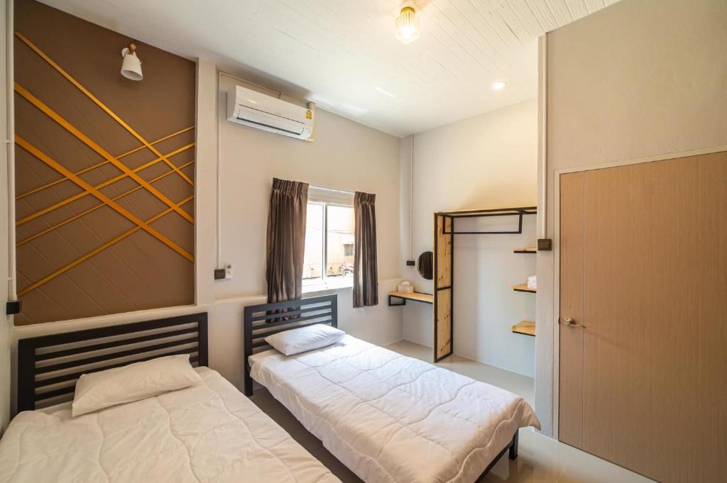 a bedroom with two beds and a window at J Villa Betong - Private House in Betong