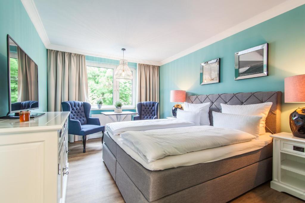 Habitación de hotel con cama, mesa y sillas en Lieblingsinsel Langeoog, en Langeoog