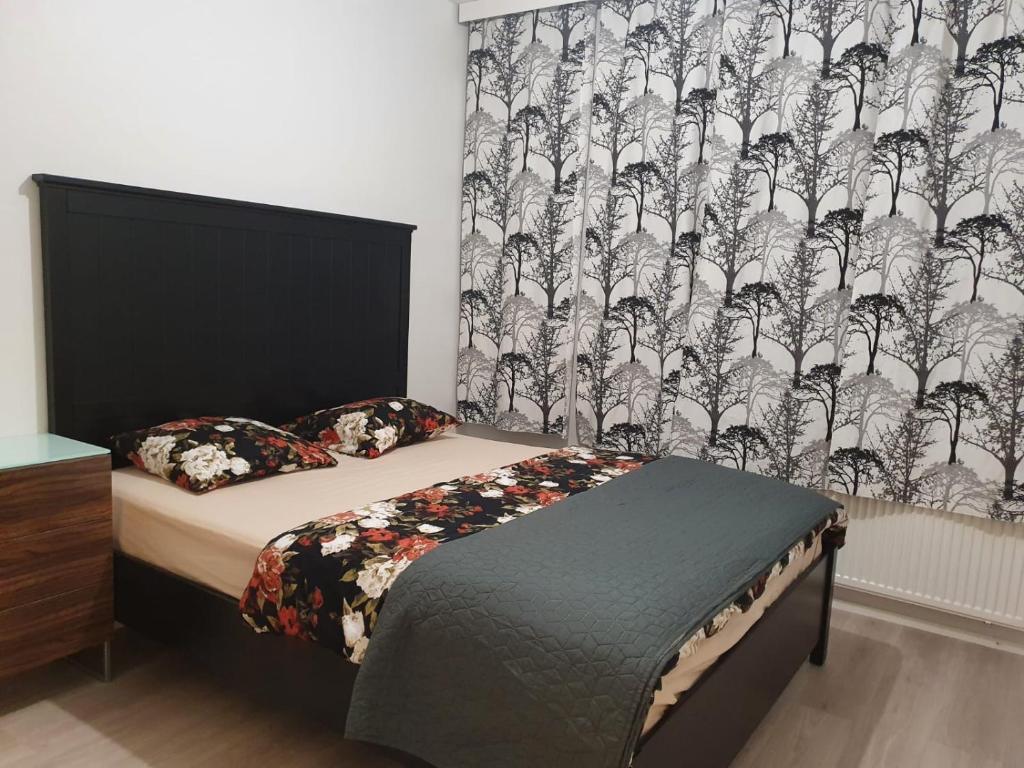 een slaapkamer met een bed met een zwart-wit gordijn bij Lovely Two Room Apartment in Helsinki in Espoo