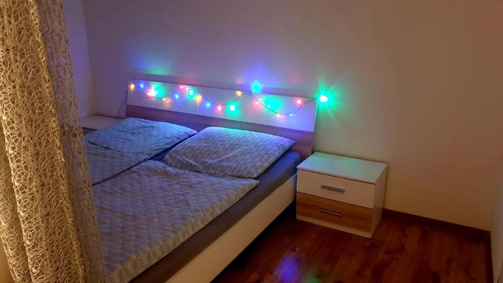 a bedroom with a bed with a headboard with lights at Apartmán Bambuľka in Slovenská ľupča
