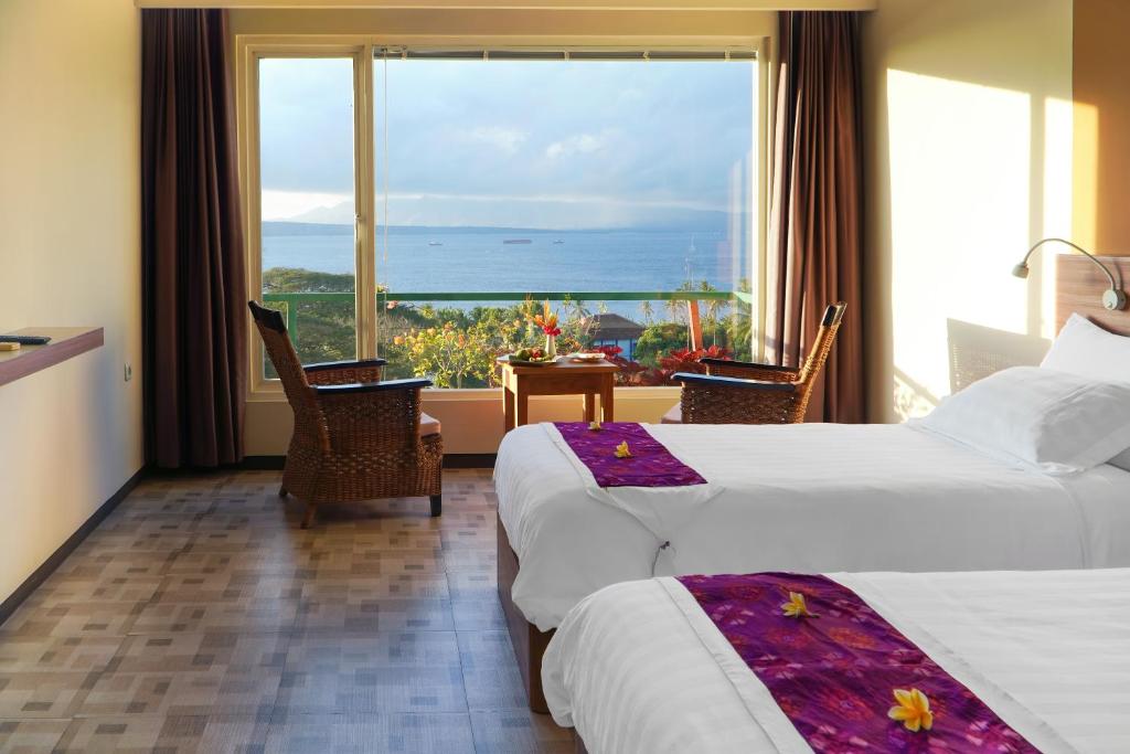 Habitación de hotel con 2 camas y ventana grande. en Bella Vista Premium Homestay, en Banyuwangi