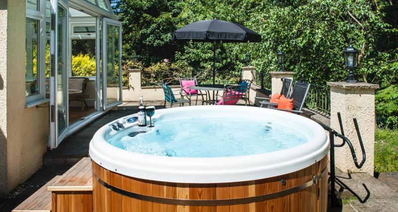 a jacuzzi tub in the backyard of a house at Acorns with own hot tub, romantic escape, close to Lyme Regis in Uplyme