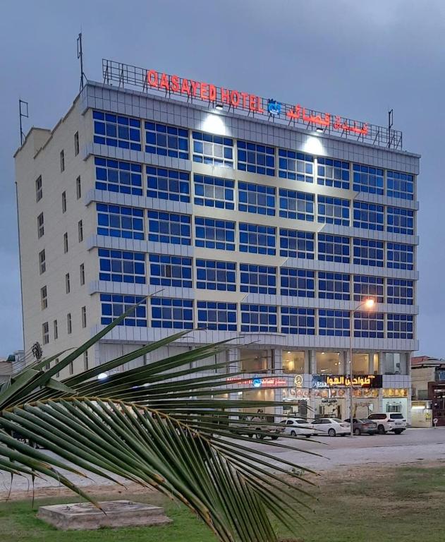 a large building with a sign on top of it at Qasayed Hotel فندق قصائد in Salalah