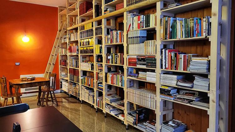 una biblioteca con varios estantes llenos de libros en B&B&Beer, en Cassano delle Murge