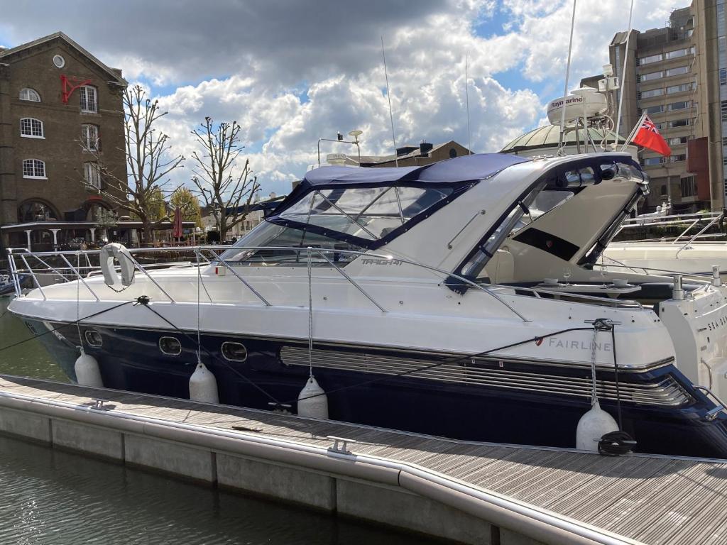 a boat is docked at a dock in the water at Entire Boat at St Katherine Docks 2 Available select using room options in London