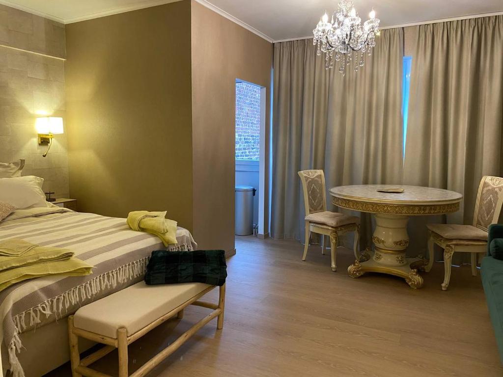 1 dormitorio con cama, mesa y lámpara de araña en Studio Montaigne en Lieja