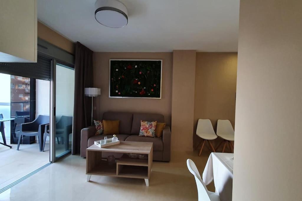 ein Wohnzimmer mit einem Sofa und einem Tisch in der Unterkunft Apartamento en primerisima linia de playa in Oropesa del Mar