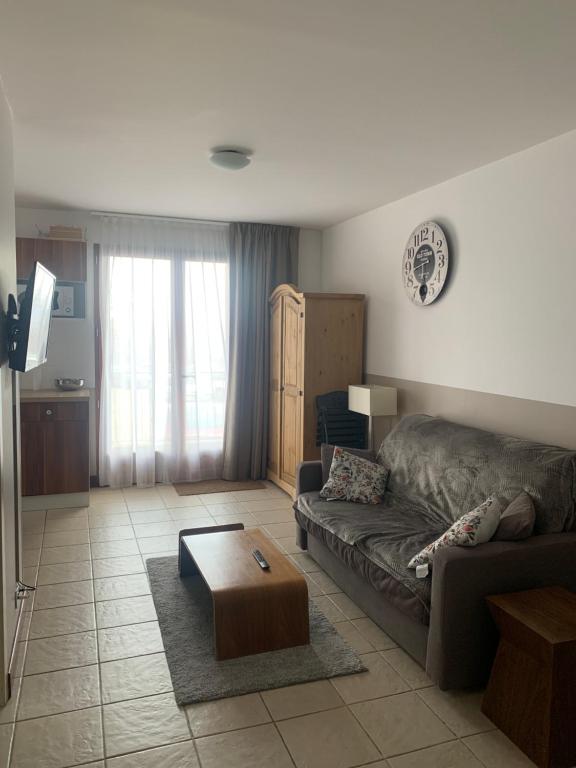 ein Wohnzimmer mit einem Sofa und einem Couchtisch in der Unterkunft Appartement T2 Centre Valberg in Valberg