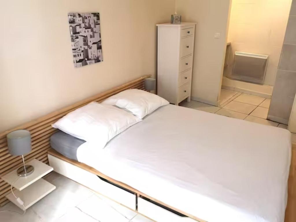 um quarto com uma grande cama branca num quarto em T2 - Coeur d'Ecusson em Montpellier
