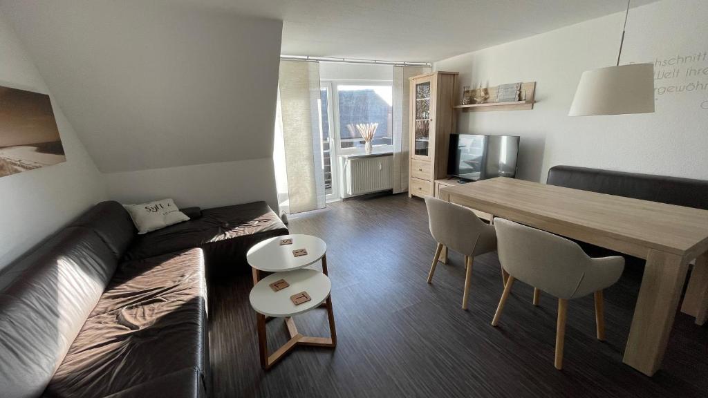 ein Wohnzimmer mit einem Sofa und einem Esstisch in der Unterkunft Apartment Yoursylt One in Westerland