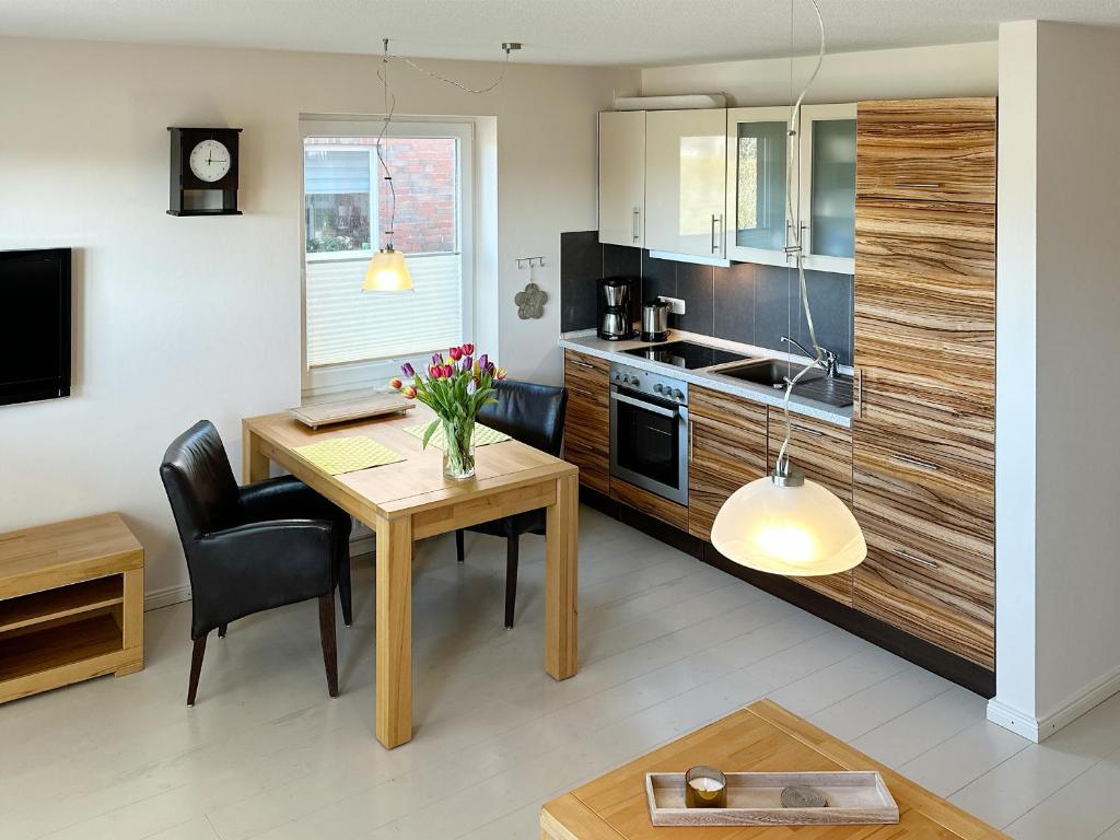 a kitchen with a table and a dining room at Ferienwohnung *Haus Ose* in Wittdün