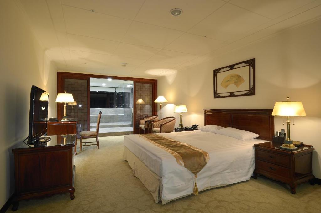 中壢區的住宿－景園大飯店，酒店客房设有一张大床和一张书桌。