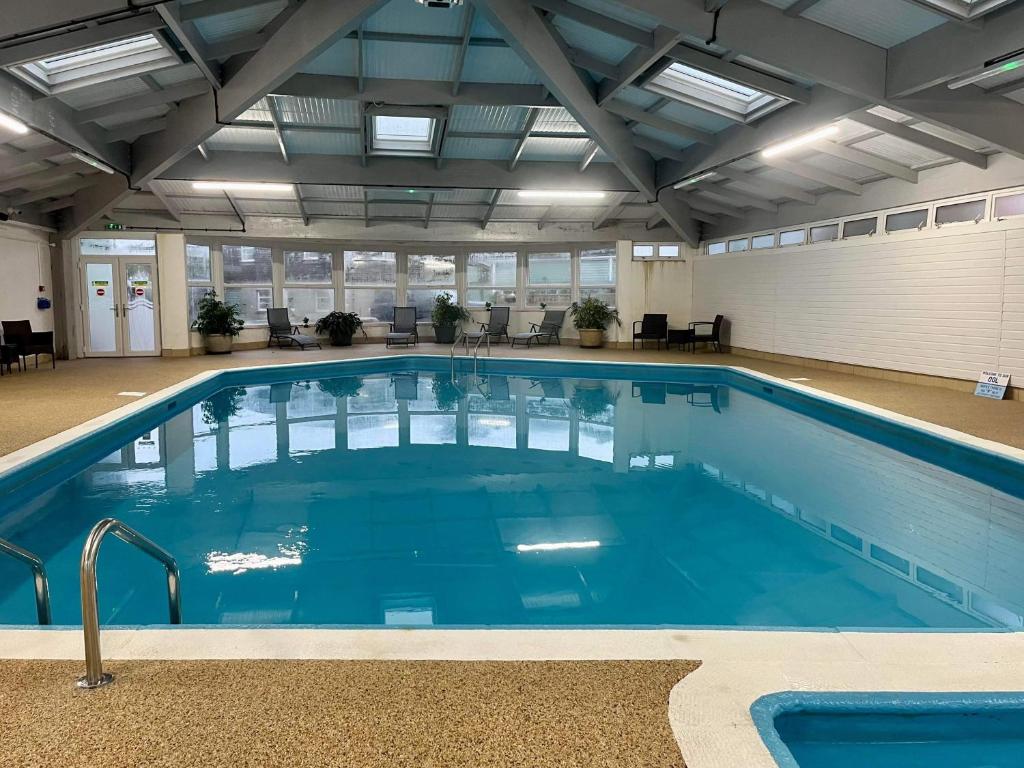 a large pool with blue water in a building at Whitsand Bay Tamar Suite in Downderry